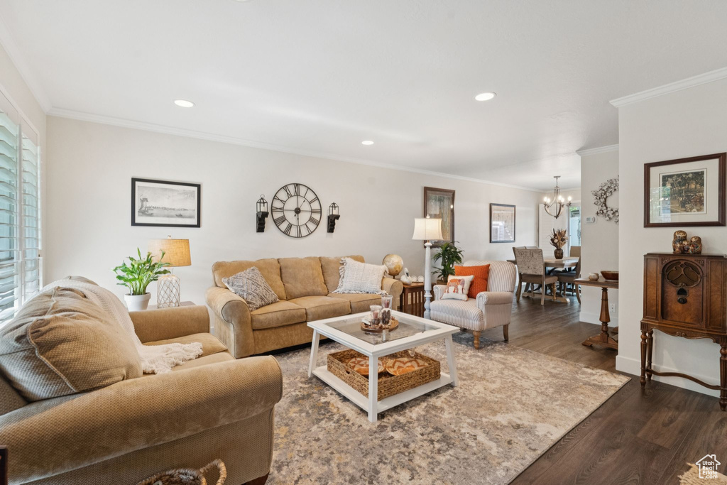 Living area featuring a chandelier, ornamental molding, dark wood finished floors, and recessed lighting