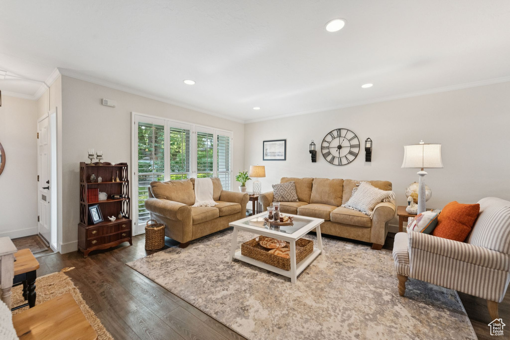 Living room with ornamental molding, wood finished floors, recessed lighting, and baseboards