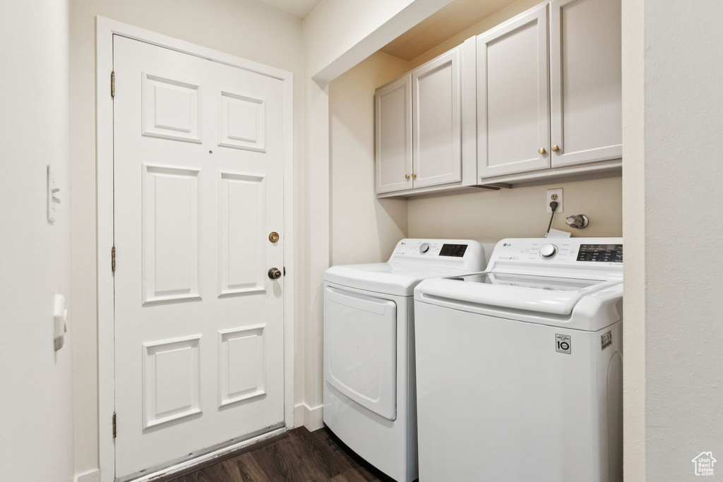 Washroom with washer and dryer, dark wood-type flooring, and cabinet space