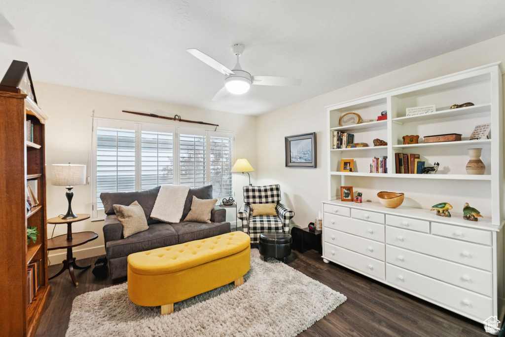 Living area featuring a ceiling fan and dark wood-type flooring