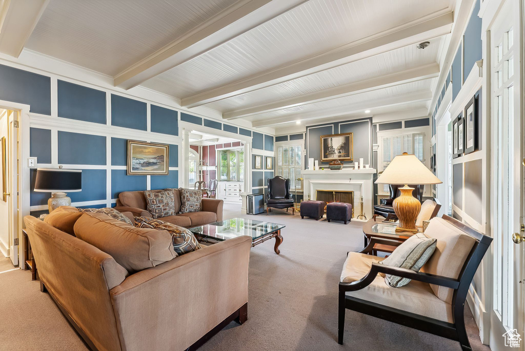 Carpeted living area with beamed ceiling and a lit fireplace