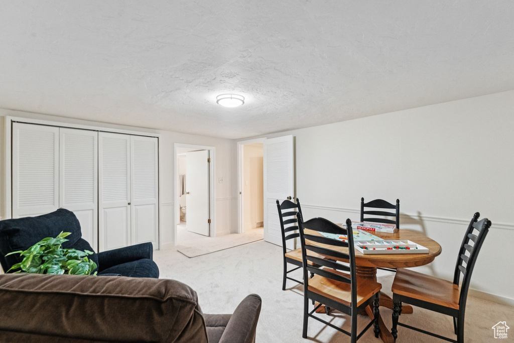 Dining area with light colored carpet and a textured ceiling