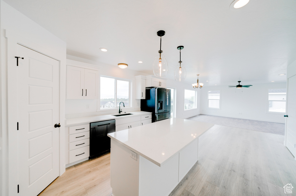 Kitchen with black appliances, healthy amount of natural light, a center island, and recessed lighting