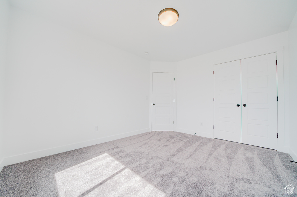 Unfurnished bedroom featuring carpet flooring and a closet