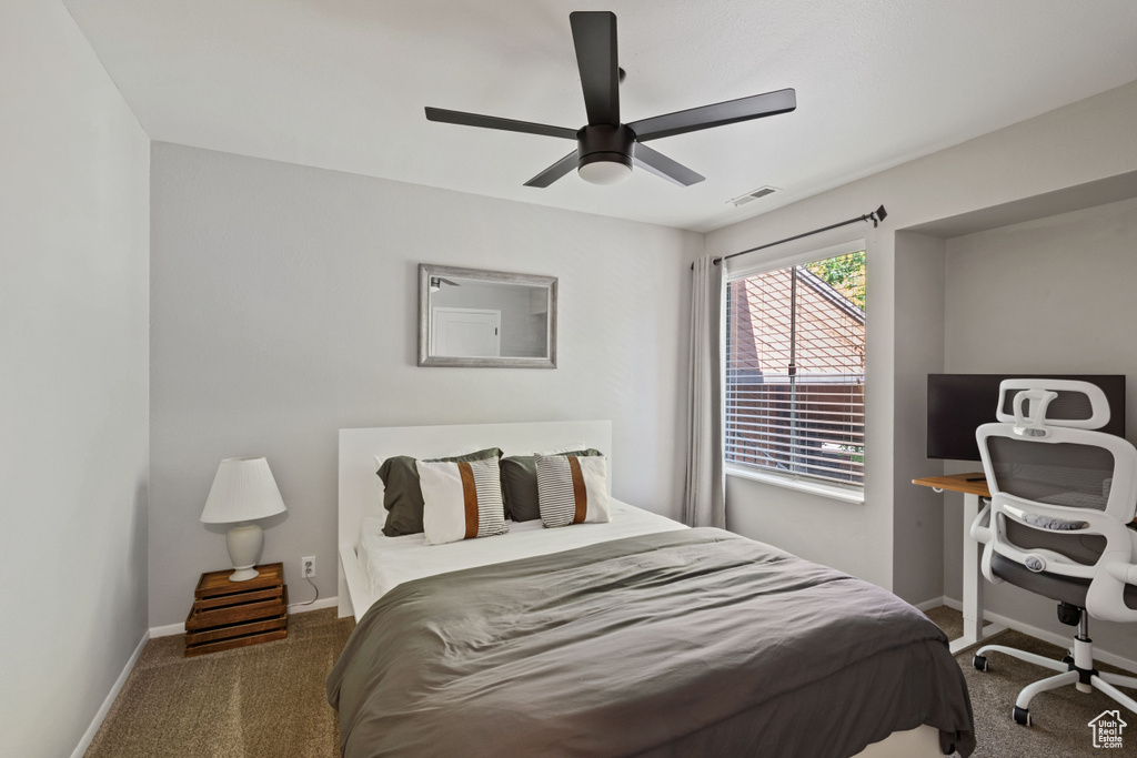 Bedroom with carpet floors, ceiling fan, and a desk