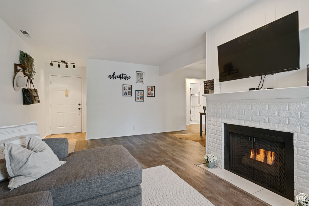 Living area with a brick fireplace and wood finished floors