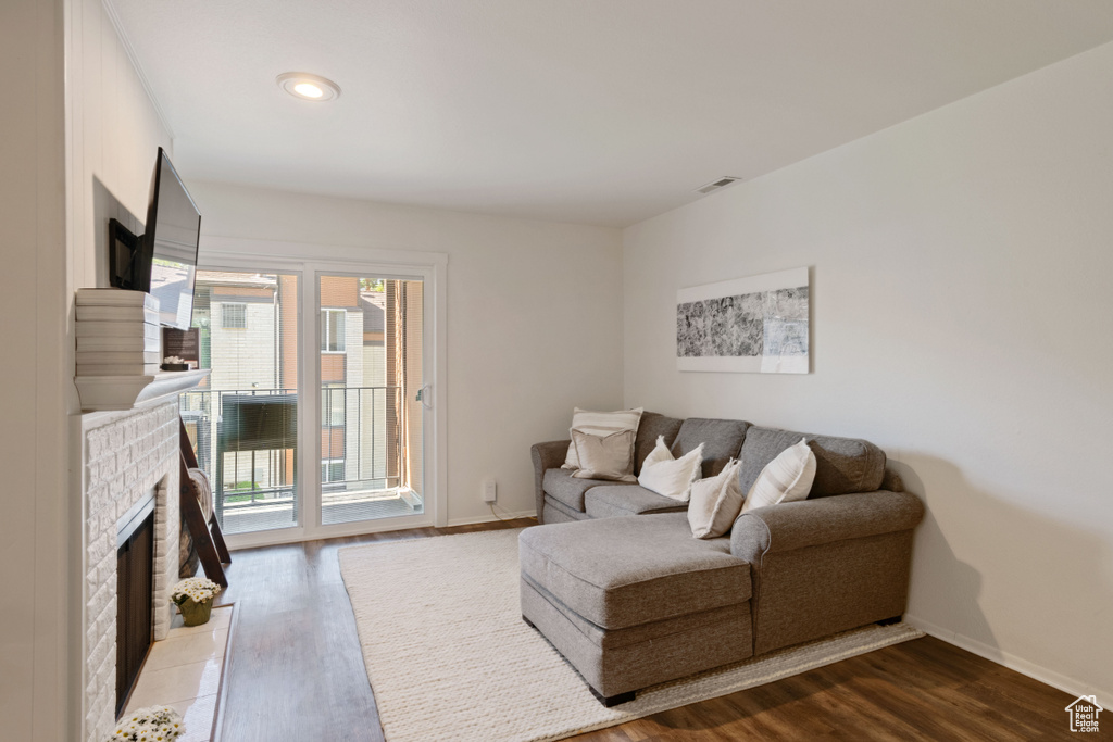 Living room featuring a fireplace, wood finished floors, and recessed lighting
