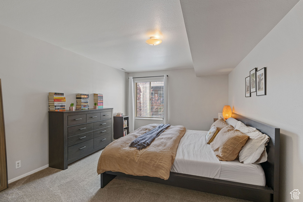 Bedroom with light colored carpet and baseboards