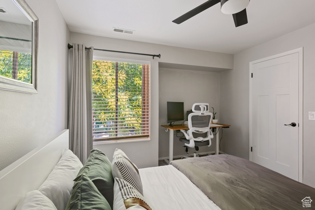 Bedroom with multiple windows and a ceiling fan