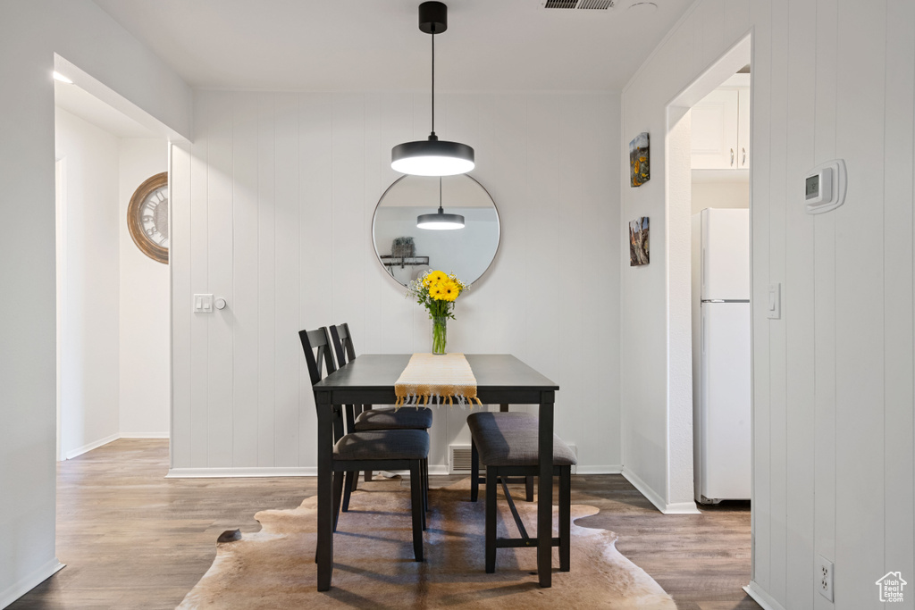 Dining space with wood finished floors and baseboards