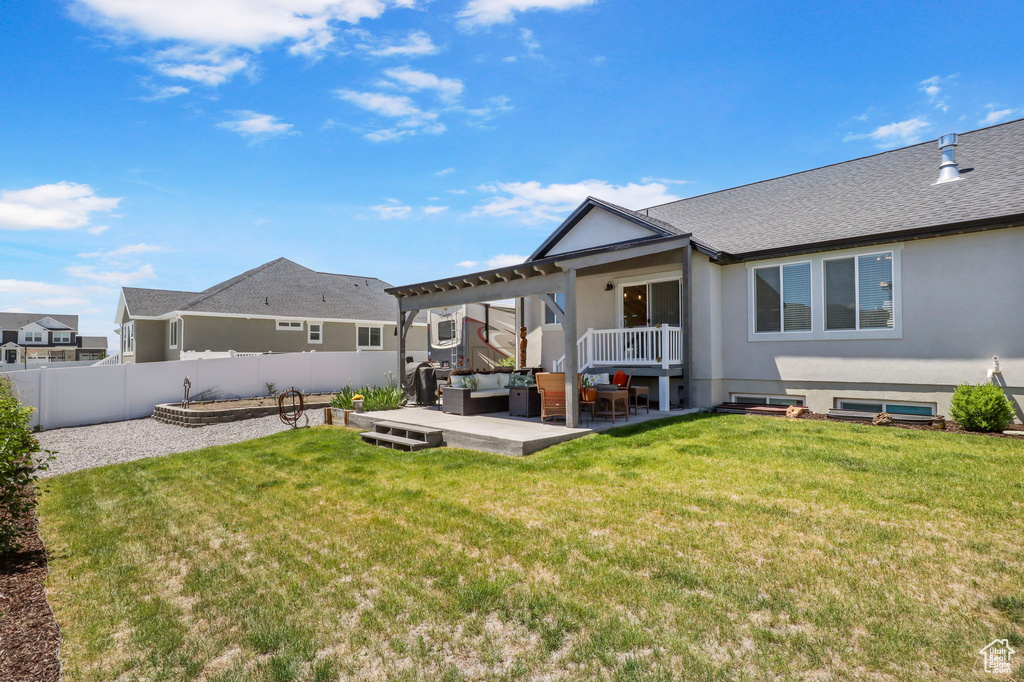 Back of property featuring outdoor lounge area, a fenced backyard, stucco siding, a patio, and roof with shingles