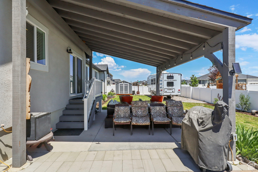 View of patio with an outdoor living space, a storage unit, and a residential view