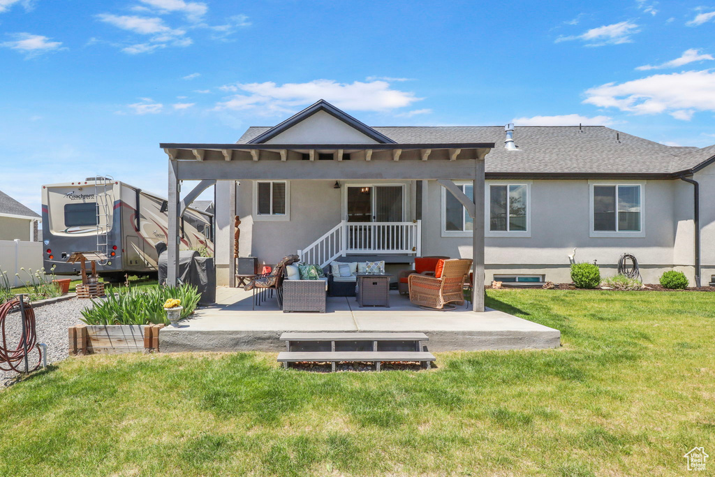 Rear view of house with an outdoor hangout area, a patio area, stucco siding, a lawn, and roof with shingles