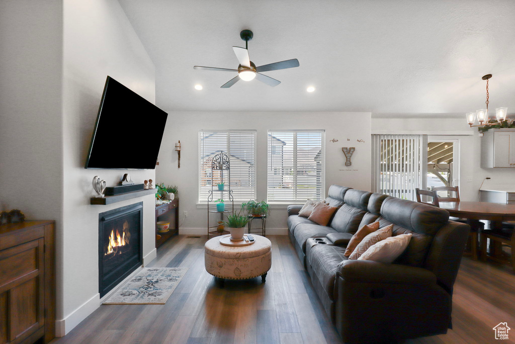 Living area featuring a chandelier, ceiling fan, plenty of natural light, a glass covered fireplace, and recessed lighting