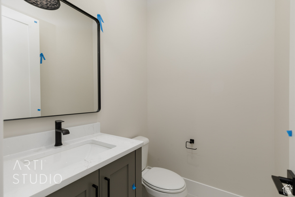 Half bathroom with vanity and toilet