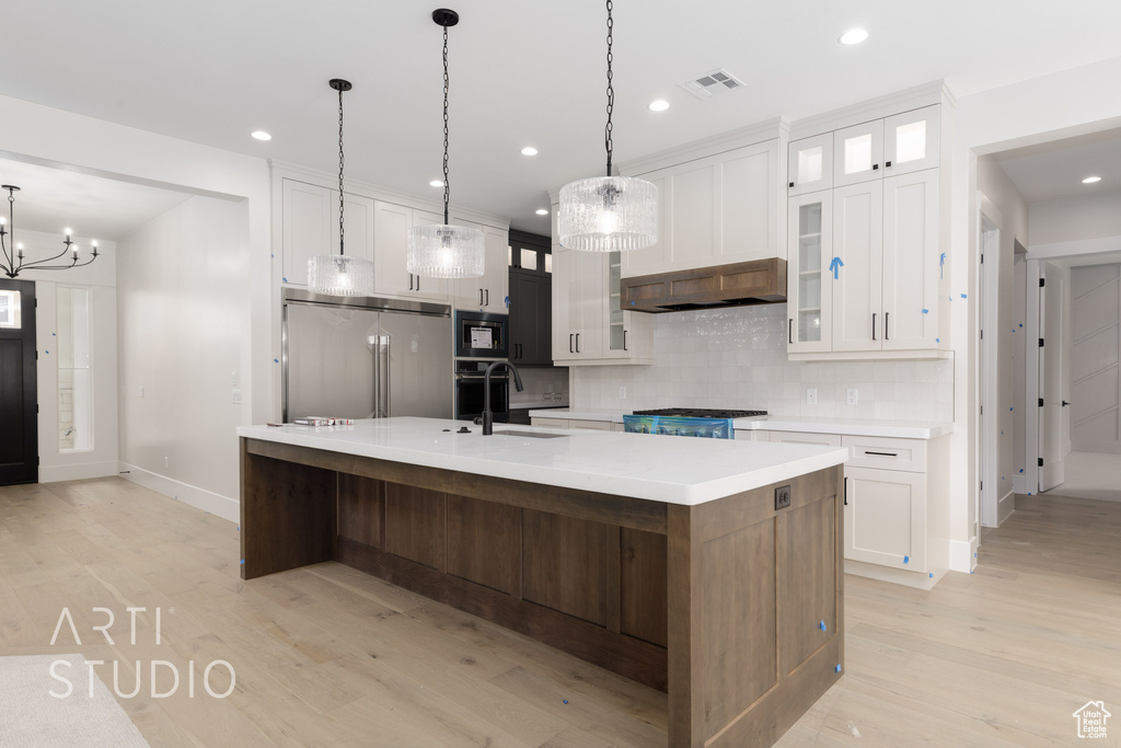 Kitchen with a sink, high quality fridge, tasteful backsplash, baseboards, and built in microwave