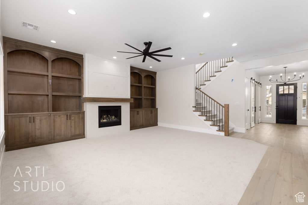 Unfurnished living room with stairs, recessed lighting, baseboards, a chandelier, and ceiling fan