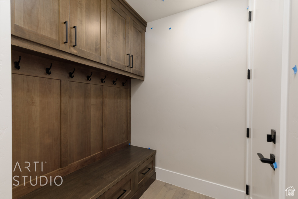 Mudroom with light wood-type flooring and baseboards