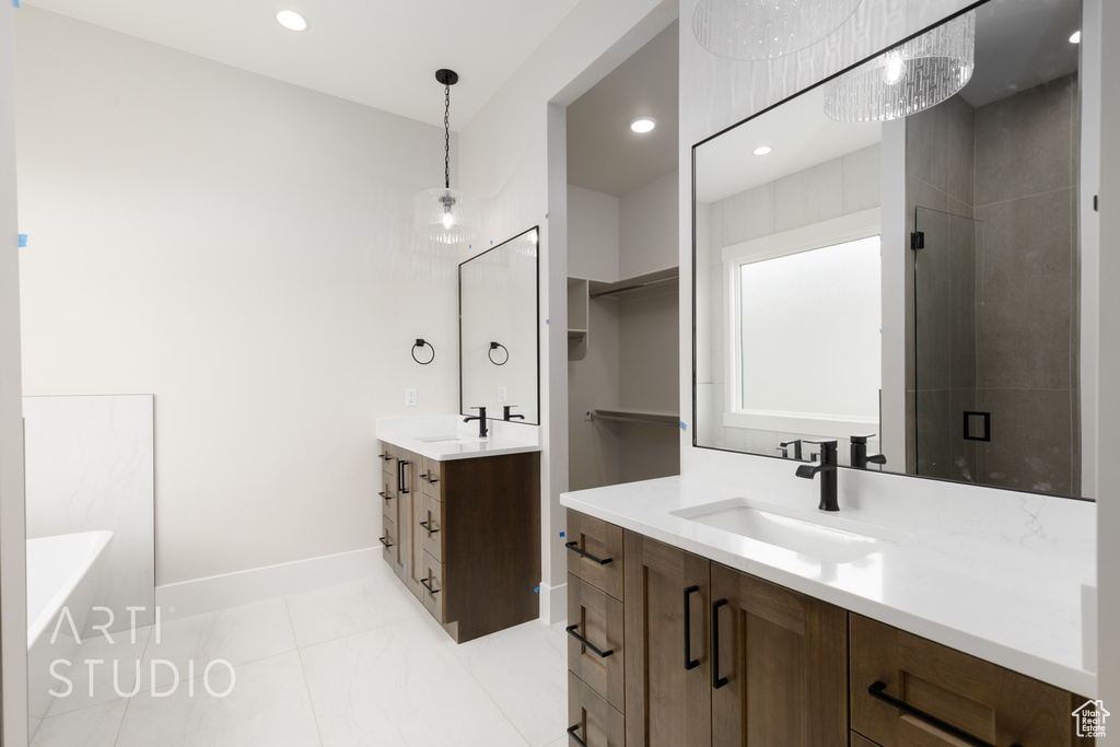 Full bath with two vanities, baseboards, a stall shower, a bath, and recessed lighting