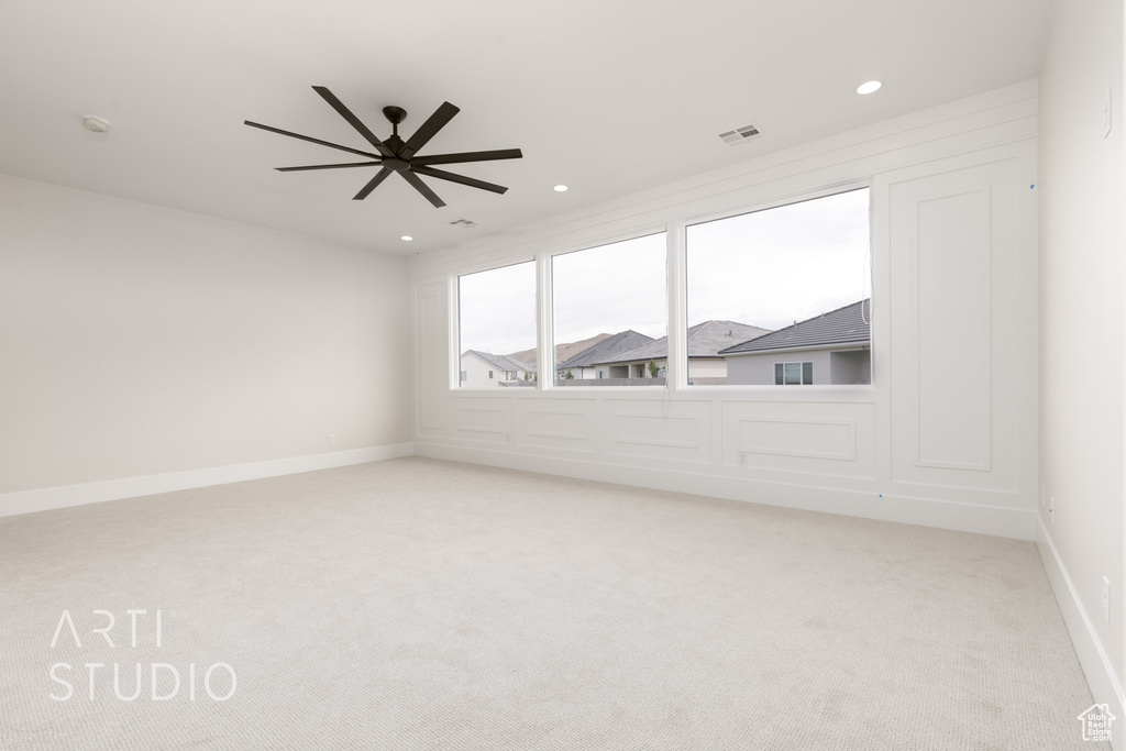 Spare room with light colored carpet, recessed lighting, a ceiling fan, a smoke detector, and baseboards