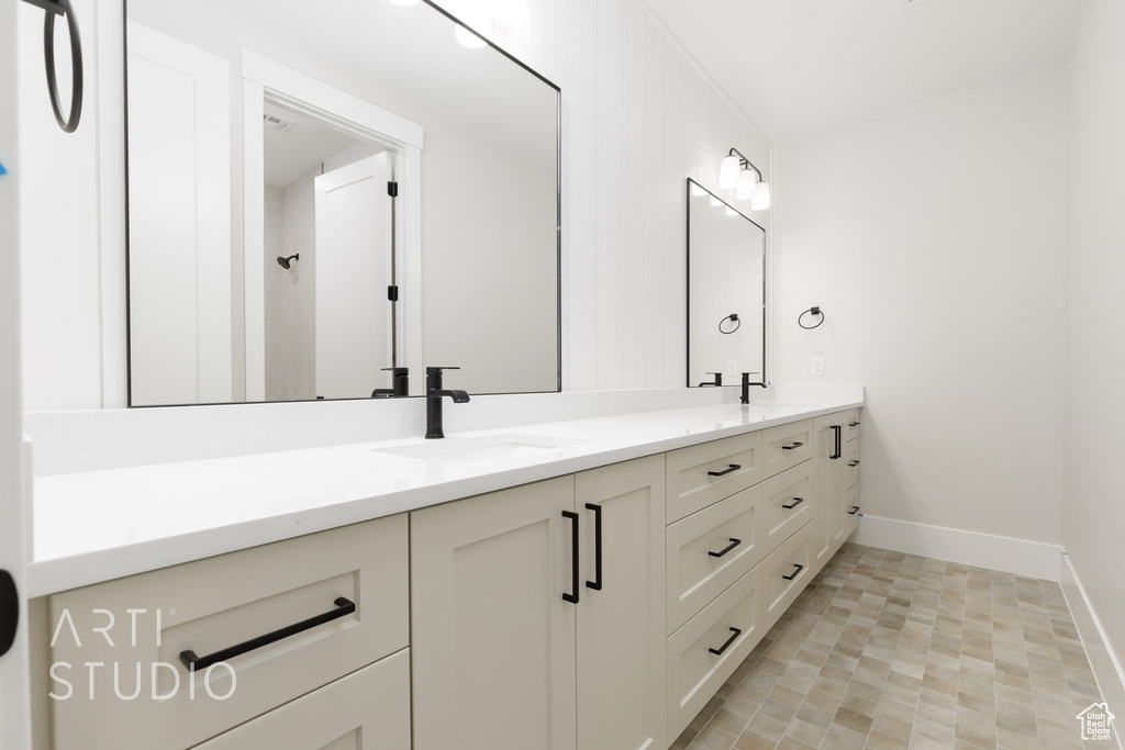 Bathroom featuring double vanity and baseboards