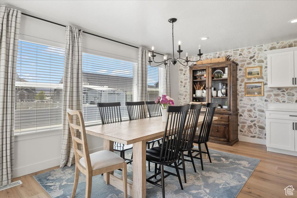 Dining area with a chandelier and light wood-type flooring