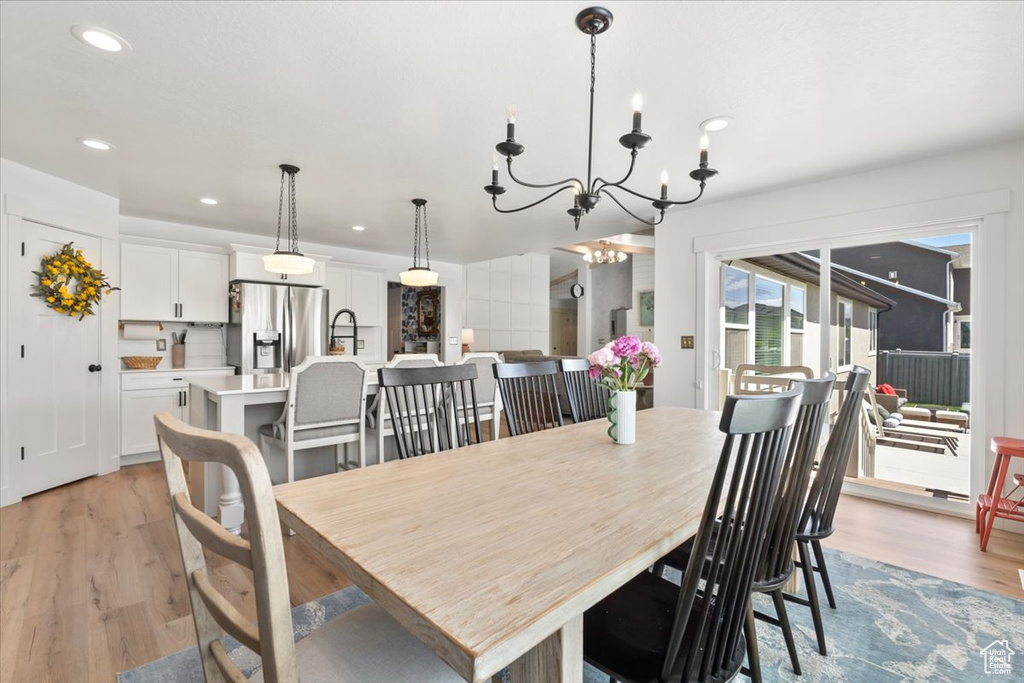Dining area with light wood-style flooring, a chandelier, and recessed lighting