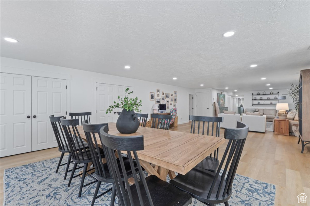Dining area with recessed lighting, light wood-type flooring, and a textured ceiling