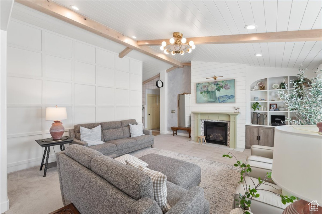Living room featuring a chandelier, a fireplace with flush hearth, and built in shelves