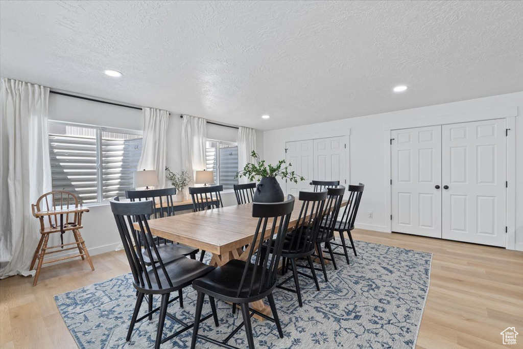 Dining room featuring a textured ceiling, light wood-style flooring, and recessed lighting
