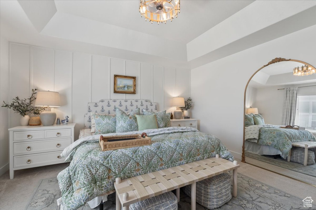 Bedroom featuring a chandelier, carpet, a raised ceiling, and arched walkways