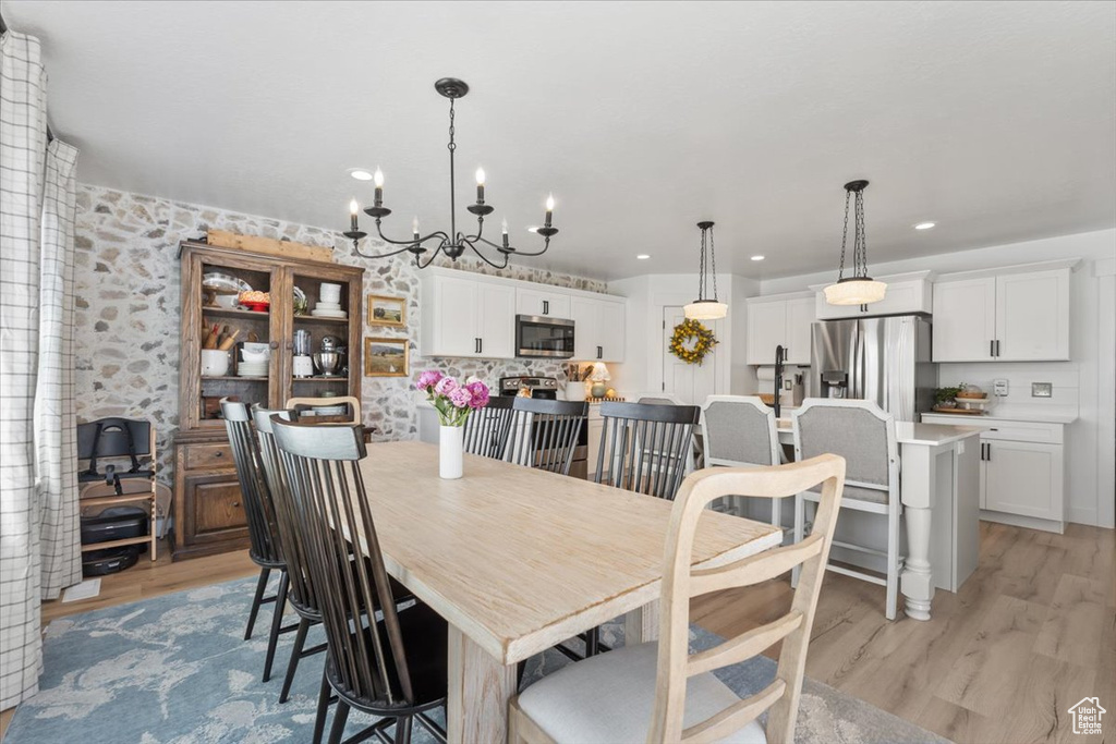 Dining area with light wood-style floors, a chandelier, and recessed lighting