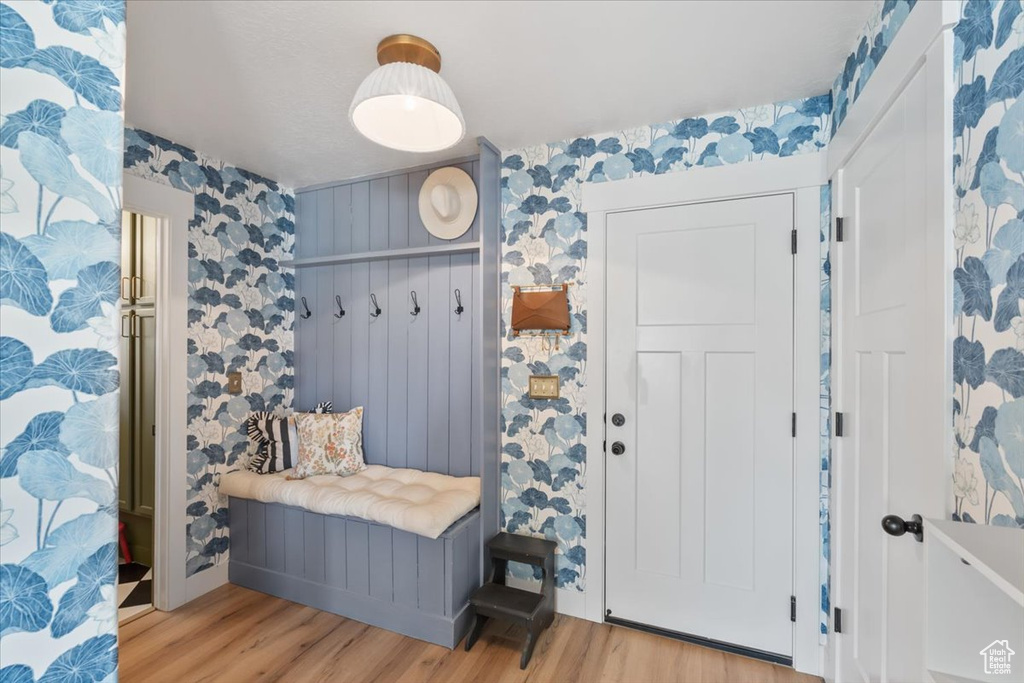 Mudroom featuring light wood finished floors and wallpapered walls