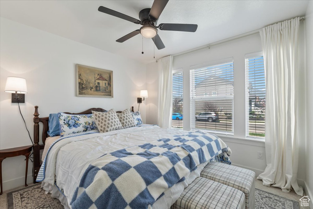 Bedroom featuring multiple windows, a ceiling fan, and carpet floors