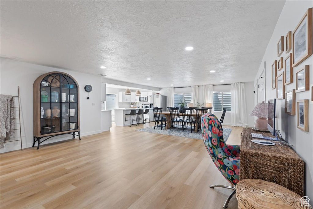 Living room featuring a textured ceiling, light wood-style floors, and recessed lighting