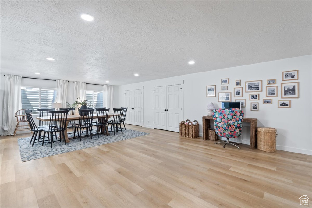 Dining area featuring a textured ceiling, light wood-type flooring, and recessed lighting