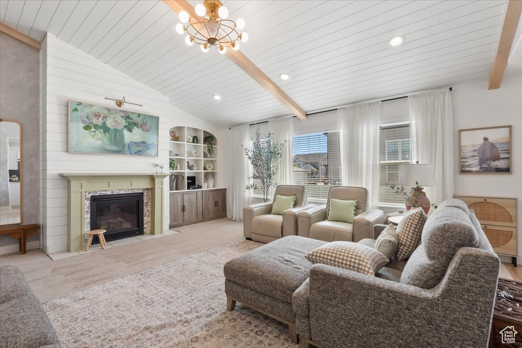 Living room with a tile fireplace, wood ceiling, a chandelier, carpet floors, and built in features