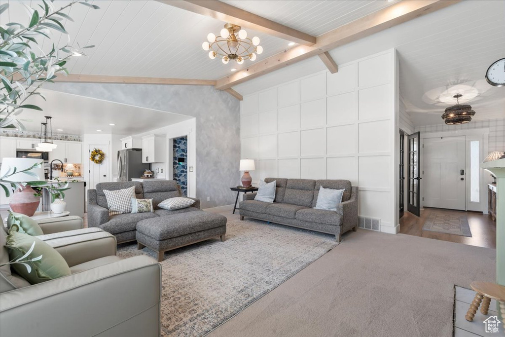 Carpeted living room with a chandelier and baseboards