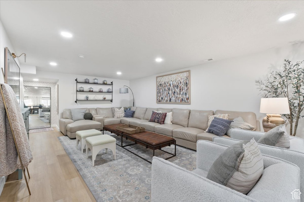 Living room with light wood-type flooring and recessed lighting