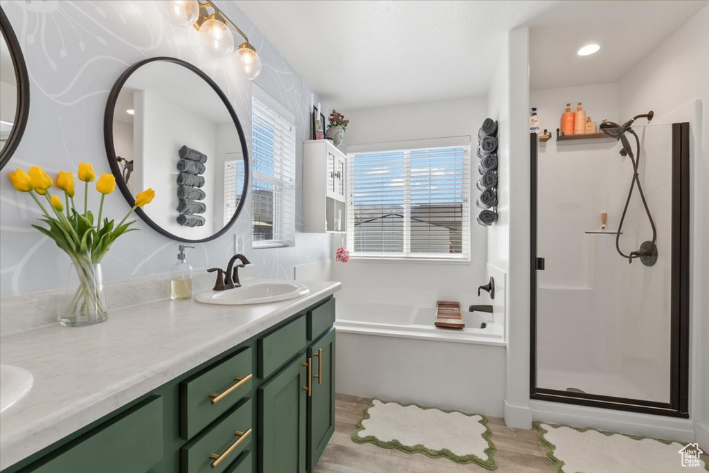 Bathroom with a garden tub, double vanity, a shower stall, and recessed lighting