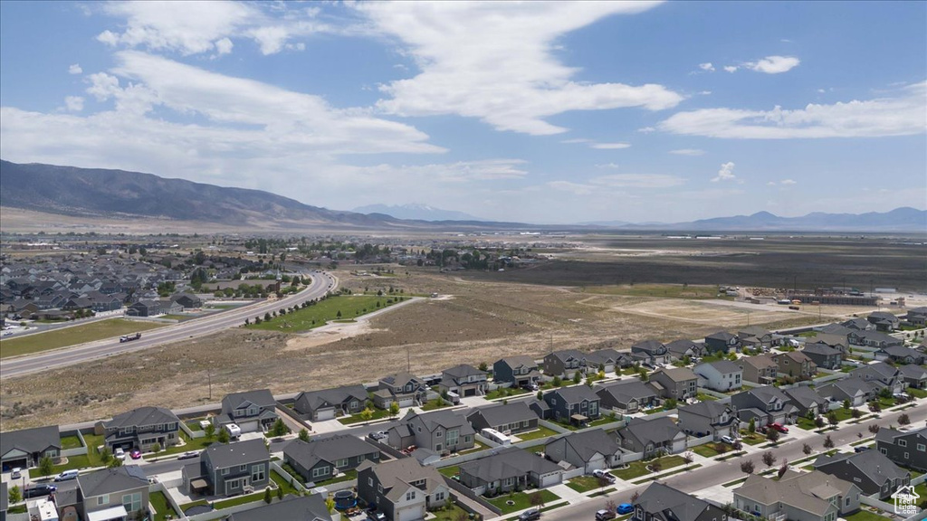 Aerial view of property and surrounding area featuring nearby suburban area and mountains