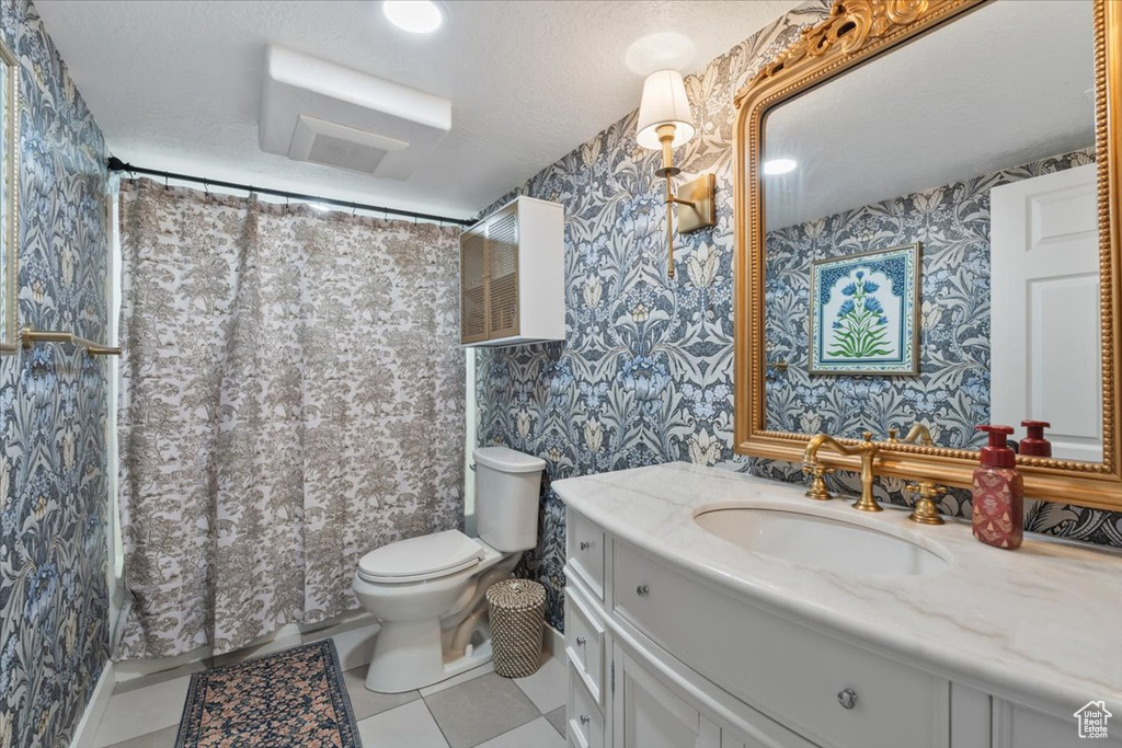 Bathroom with wallpapered walls, vanity, tile patterned flooring, and curtained shower