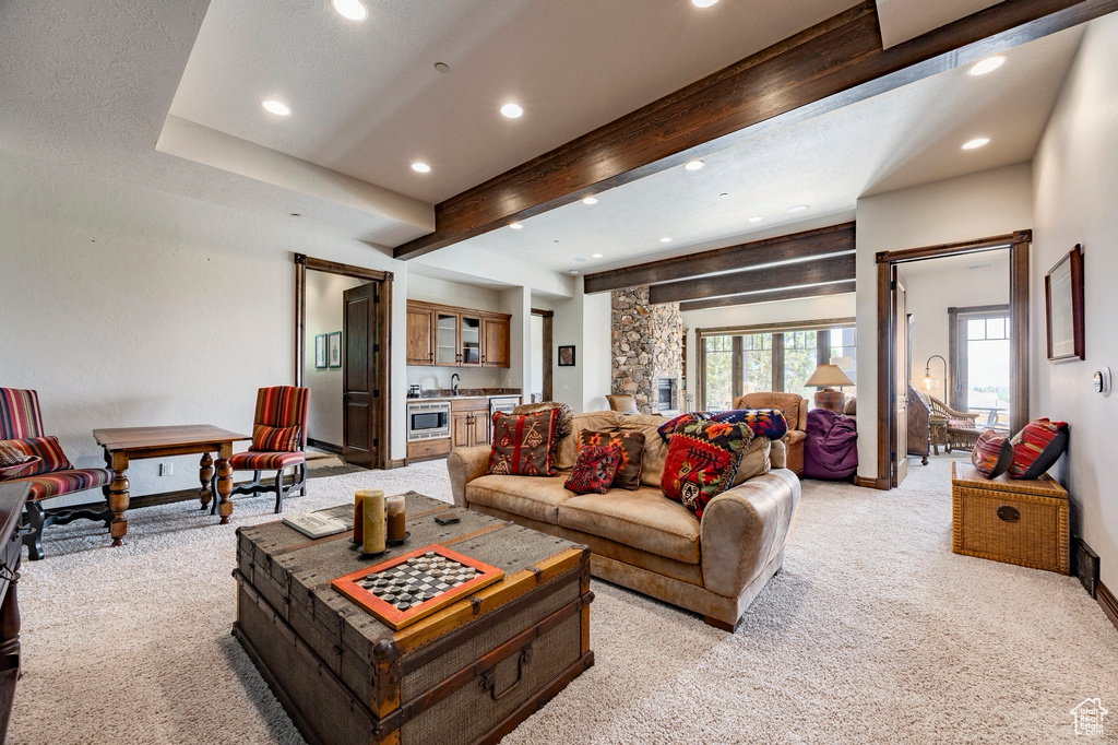 Living room with light colored carpet, recessed lighting, beamed ceiling, and bar