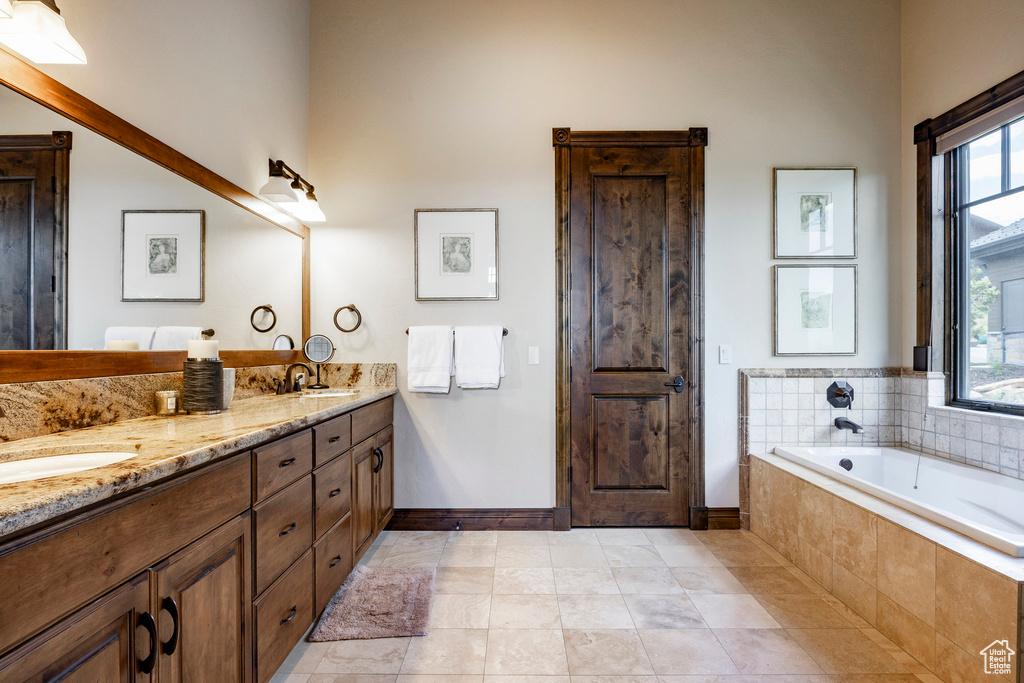Bathroom with double vanity, a bath, and tile patterned flooring