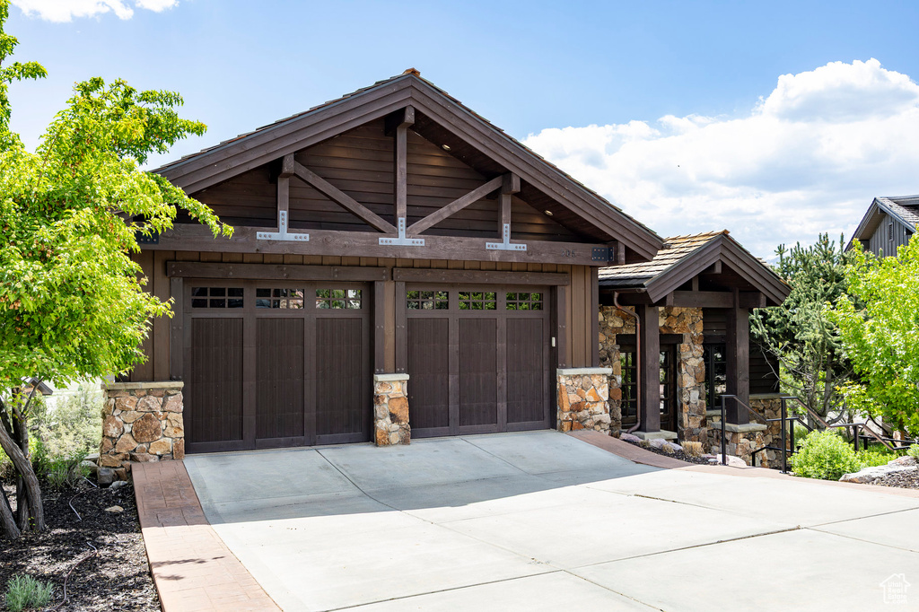 Craftsman house featuring stone siding and driveway
