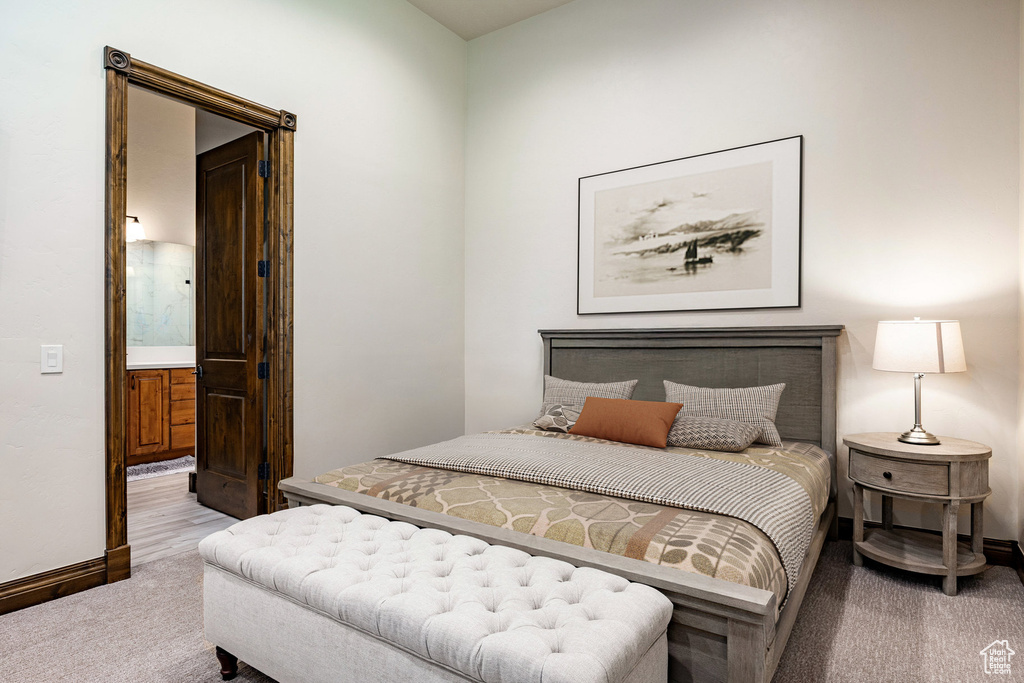 Carpeted bedroom featuring baseboards and ensuite bathroom