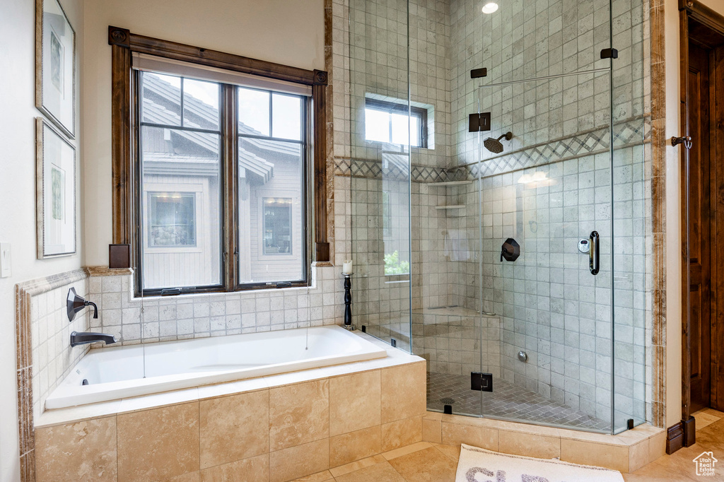 Bathroom featuring a shower stall, a bath, and tile patterned flooring