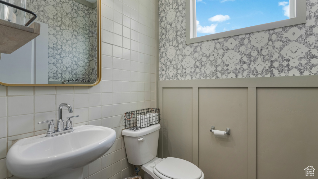 Half bath featuring tile walls