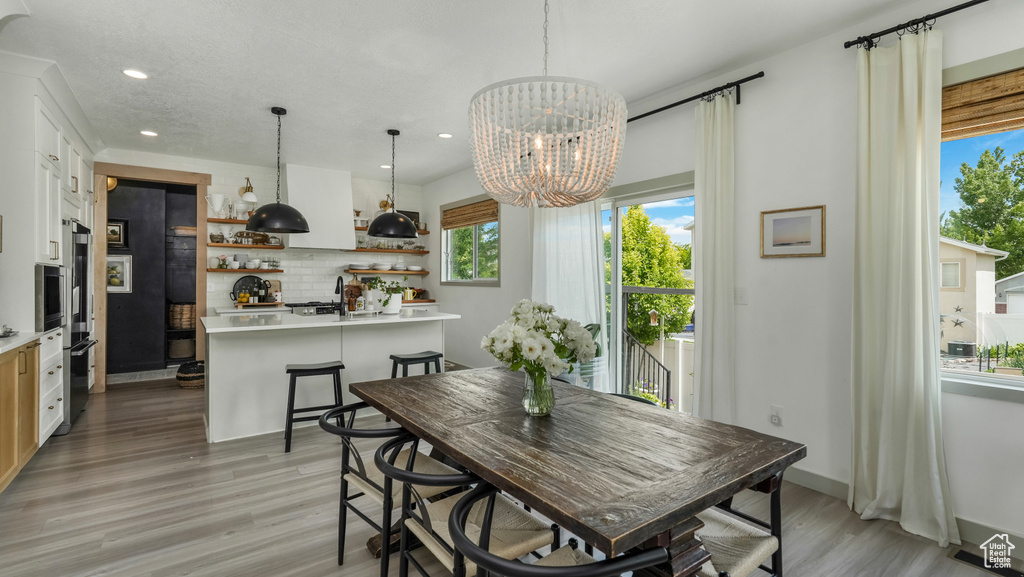 Dining room featuring recessed lighting, light wood-style flooring, and a chandelier