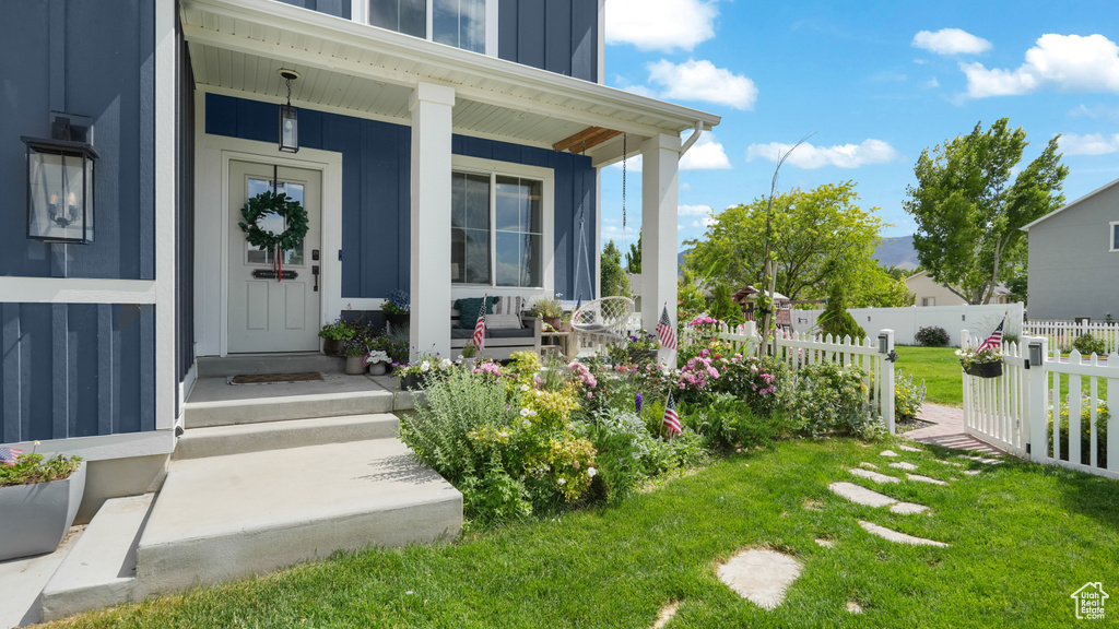 Entrance to property featuring board and batten siding and a porch